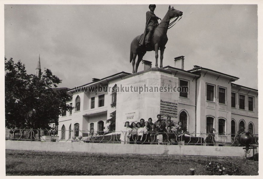 Heykel önünde fotoğraf çektiren bir topluluk.